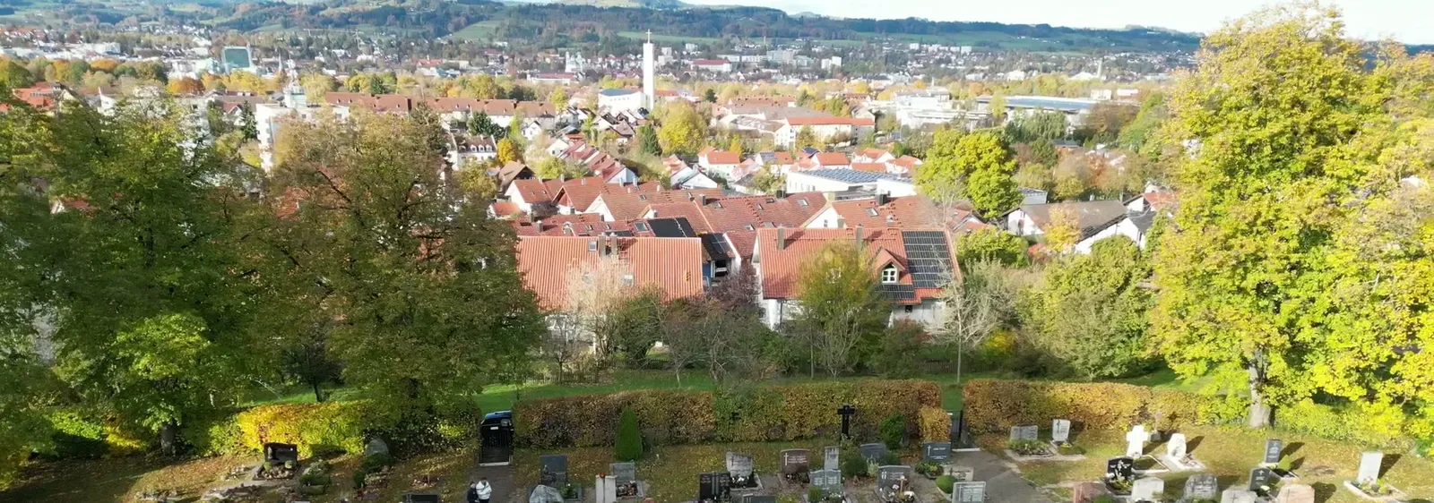 Blick vom Friedhof Lenzfried über die Dächer von Kempten im Herbst, im Vordergrund Grabreihen – STOI Steinmetzwerkstatt