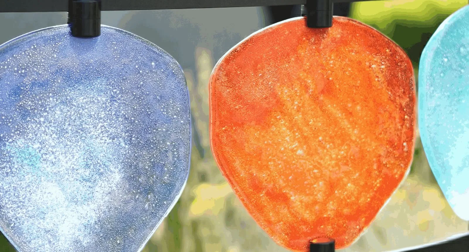 Blaue, orange und türkise Glasscheiben des Urnengrabfelds HIMMELREICH MEMORIAL ganz nah im Gegenlicht – STOI Steinmetzwerkstatt