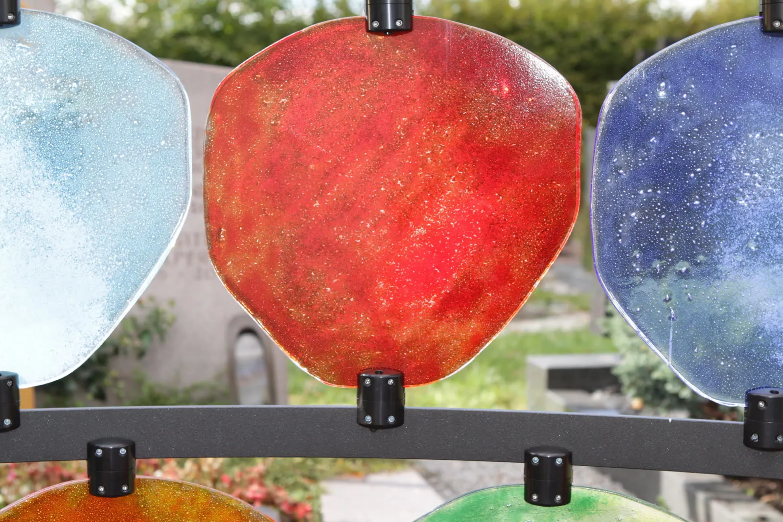 Rote Glasscheibe ganz nah zwischen hellblauen und blauen Gläsern – STOI Steinmetzwerkstatt